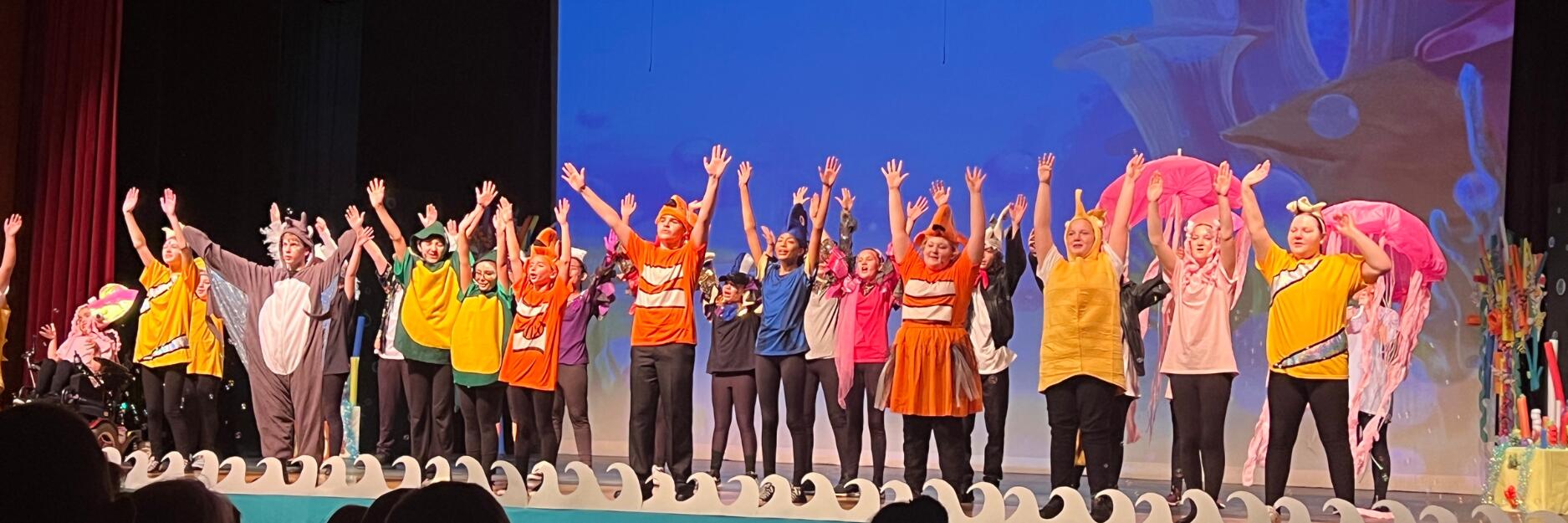 Students dressed as marine animals and fish taking a bow on stage